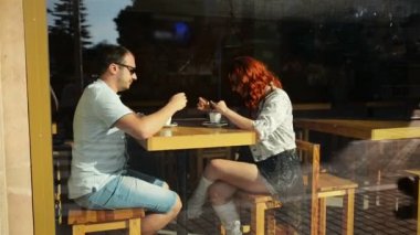 Mutlu çift bir kafede romantik bir tarih var. Birbirlerinin ellerini tutuyorlar. Çok şirin görünüyor..