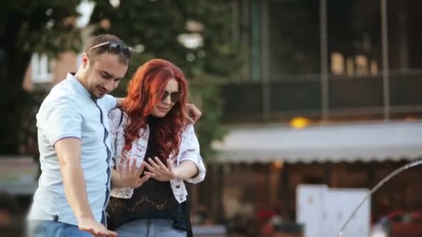 Pareja romántica acurrucándose contigo mismo al aire libre. Tienen buen humor pasando tiempo juntos. Fuente está en el fondo . — Vídeos de Stock