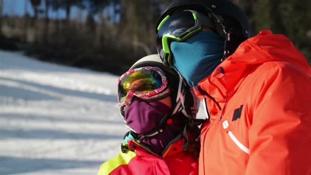 雪のリゾートで若いカップルの肖像画。彼らはスキー用ゴーグル、ヘルメットを着用します。. — ストック動画