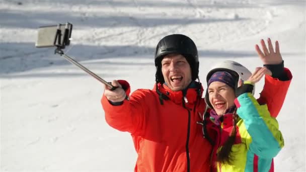 Boldog pár birtoklás móka a hóban, és így Selfie. Mosolygó pár. Nekik van a jó hangulatban tölteni az időt. — Stock videók