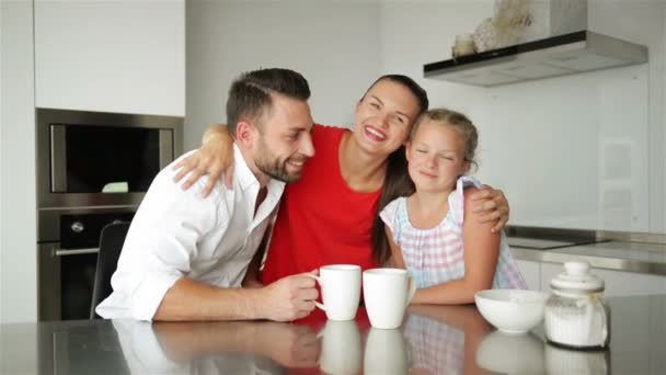 Glückliche Familie, die Zeit miteinander verbringt. Sie haben viel Spaß beim Sitzen und Reden in der modernen Küche. — Stockvideo