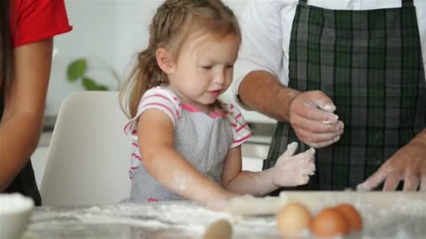 Матері допомагає її дочка замісити тісто. У них дуже весело разом. — стокове відео