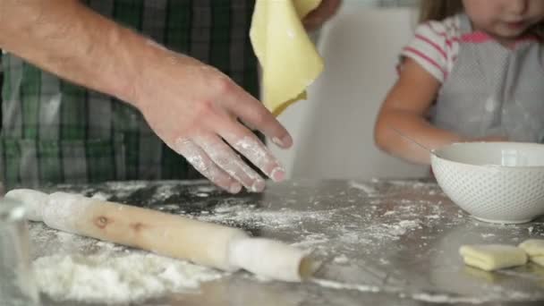 Junge Eltern lernen ihre Töchter kochen. Sie zeigen alle Kochvorgänge. — Stockvideo