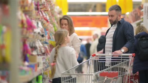 Hermosa pareja y su hija se divierten mientras hacen compras en el supermercado . — Vídeos de Stock