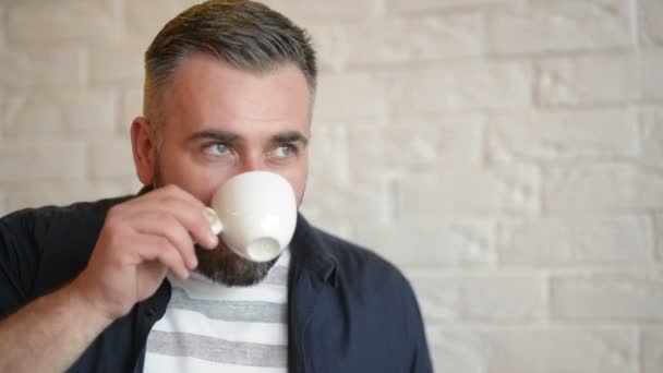 Bel homme barbu se détendre dans le café et boire du café ou du thé. Bonne humeur . — Video