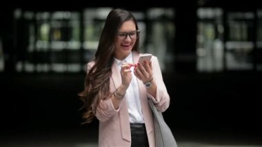 Mutlu Iş kadın sokakta duran bir akıllı telefon kullanır. Iyi haberler alıyor. Telefon konuşma