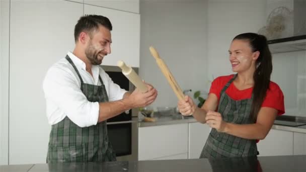 Glückliches Paar hat einen lustigen Kampf in der Küche. Sie sind gut drauf. — Stockvideo