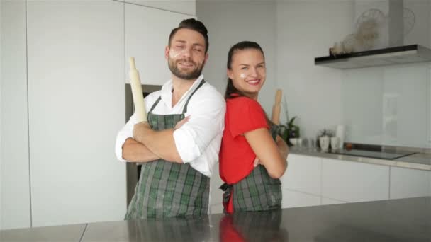 Portrait horizontal de la femme surprise penche sur les maris épaule être choqué qu'il n'est pas fatigué après avoir aidé à préparer la pizza, a confiance et la force. Couple travaillent en équipe sur la cuisine . — Video