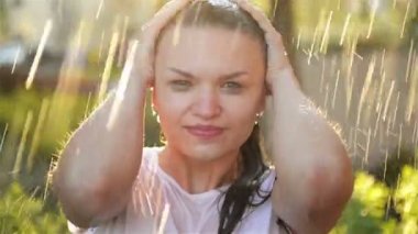 Genç Kadın Yağmur altında Gülümsüyor ve Gülüyor. Yağmur Damlaları Yüzüne Düşer ve O Etrafında Yaşam ve Doğa ile Mutludur. Doğa ve Mutlu Yaşam Kavramı, Macera, Saflık