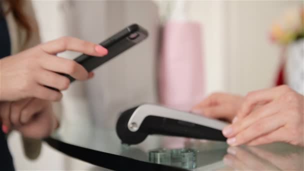 Jonge vrouw als klant betaalt Cashless met Smartphone App bij de Card Terminal. — Stockvideo