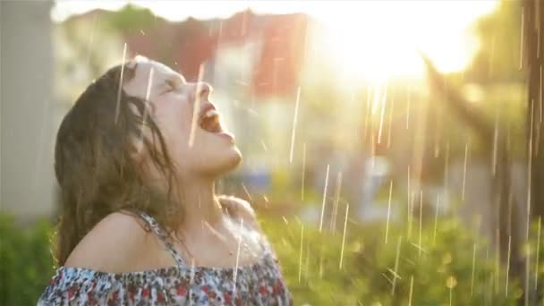 Les enfants jouent sous la pluie d'été. Enfant jouant en plein air le jour de la pluie. Petite fille attrapant des gouttes de pluie sous la douche lourde. Tempête d'automne dans un parc. Enfants en plein air par tous les temps . — Video