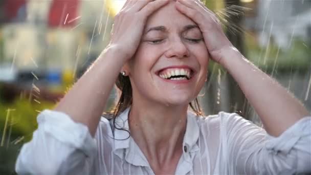 Gelukkige jonge lachende vrouw die plezier heeft in regenachtig weer. Vrolijke dame heeft nat haar in zomer Park. — Stockvideo