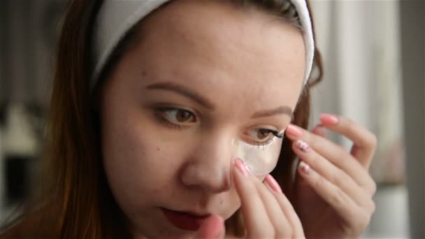 Skönhet hudvård. Vacker flicka tillämpa vit näsa lapp på ansiktshud. Närbild ung kvinnlig modell med frisk naturlig makeup och slät mjuk hud med Porrengöringsremsor. — Stockvideo