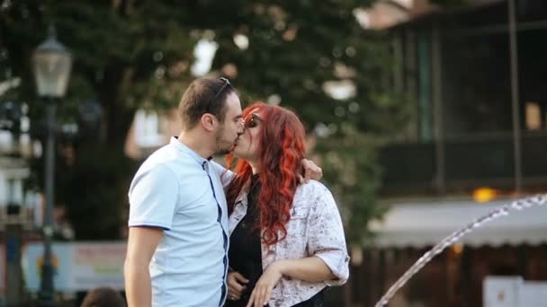 Pareja romántica acurrucándose contigo mismo al aire libre. Tienen buen humor pasando tiempo juntos. Fuente está en el fondo . — Vídeos de Stock