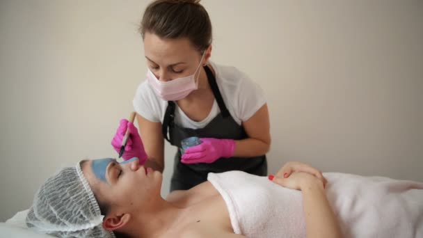 Masque Peeling Visage, Soins de beauté Spa, Soins de la peau. Femme recevant des soins du visage par l'esthéticienne au Spa Salon. Femme fait un masque d'alginate. Fille avec un masque d'argile beige . — Video