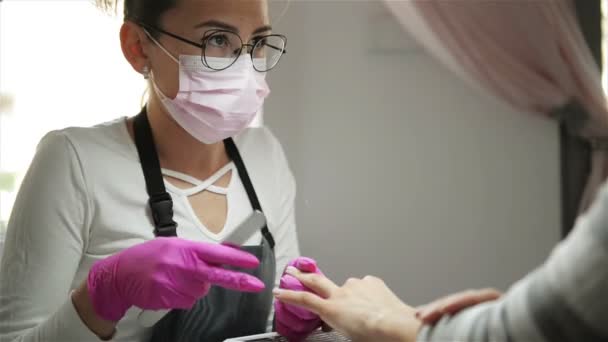 Especialista en manicura pulido de uñas al cliente. Nail Beautician Filing Nails To Woman In Nail Salon (en inglés). Caucásica mujer está consiguiendo manicura . — Vídeo de stock