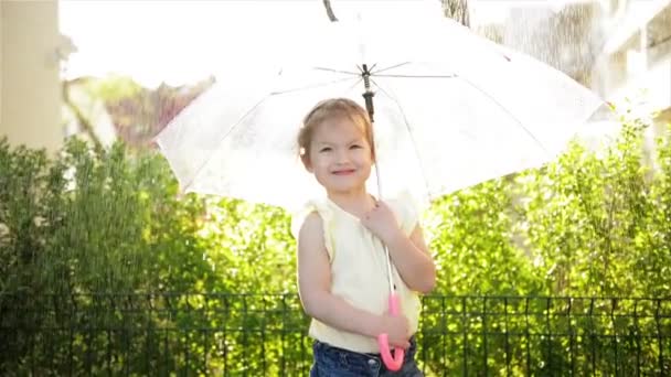 Маленькая девочка с зонтиком, улыбающаяся в парке на тропе. Slow Motion . — стоковое видео
