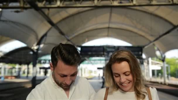 Молода щаслива пара встає з багажем на ескалаторі до зони відправлення аеропорту під час їх літніх канікул . — стокове відео