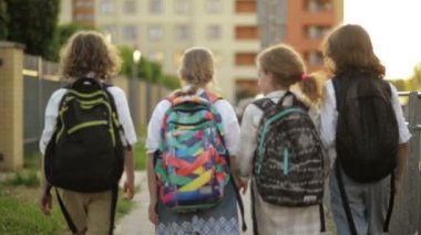 Çocuklar Okula Gidiyor. Çok eğleniyorlar çünkü bugün okuldaki ilk günleri. Arka taraftan görünüm