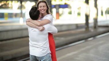 Mutlu Çift Tren İstasyonu Platformu üzerinde kucaklayan. Tren Istasyonunda Elveda, Genç Kız ve Adam Platformda Kucaklıyor.
