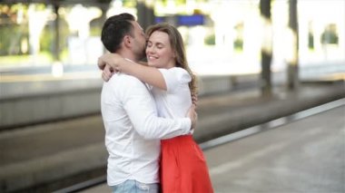 Mutlu Çift Tren İstasyonu Platformu üzerinde kucaklayan. Tren Istasyonunda Elveda, Genç Kız ve Adam Platformda Kucaklıyor.