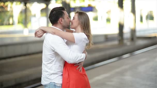 Pareja feliz abrazando en la plataforma de la estación de tren. Adiós en la estación de tren, chica joven y chico están abrazando en la plataforma . — Vídeos de Stock