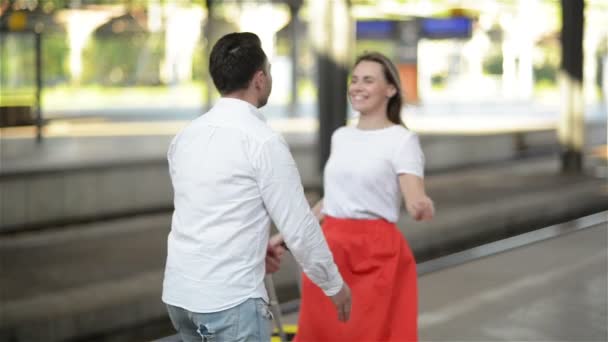 Casal jovem feliz em se encontrar novamente na estação de trem. Menina corre para conhecer seu namorado . — Vídeo de Stock