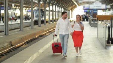Mutlu Gülümseyen Genç Çift Tren İstasyonu Platformu üzerinde çalışan. Birbirleriyle konuşuyorlar..