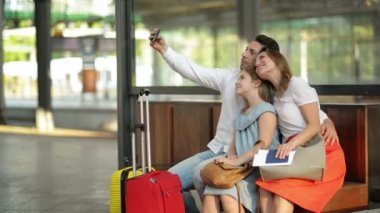 Tatil Zamanı Kayalar. Gülümseyen Güzel Aile Havaalanında Uçuş beklerken Akıllı Telefon ile Selfie Taking veya Tren İstasyonu'nda Tren.