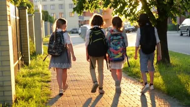 Quattro amici vanno a scuola. Hanno un sacco di divertimento perché oggi è il loro primo giorno a scuola . — Video Stock