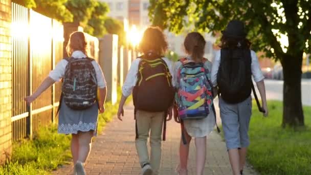 Fyra vänner kommer till skolan. De har massor av kul eftersom idag är deras förstadagen i skolan. — Stockvideo