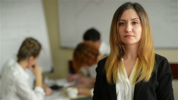 Zakelijke vrouw met haar personeel, mensen groep in de achtergrond op moderne lichte kantoor binnen — Stockvideo