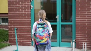 Sırt Çantalı Çocuklar Okula Gidiyor. İki erkek ve iki kız okulun yakınındaki derslere dönüyorlar. Okula Dönüş