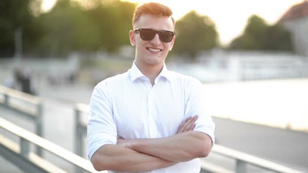 Portrait d'un étudiant séduisant séjournant à l'extérieur. Jeune homme prospère portant une chemise blanche . — Video