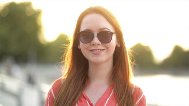 Portret van een aantrekkelijke jonge vrouw die goed kijkt naar de camera die glimlacht en lacht. Close-up weergave van meisje met Kaukasische verschijning. — Stockvideo