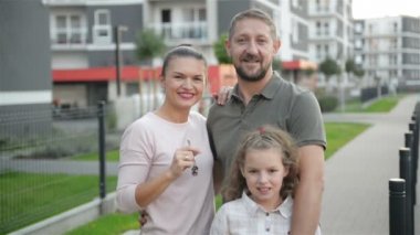 Mutlu aile açık Holding anahtar taşı-in büyük kır evi ayakta çocuklarla. Lüks gayrimenkul sahipleri çift gülümseyen ve çocuk kucaklayan Caddesi üzerinde yeni ev satın alma sonra. Mortgage kredi kavramı.