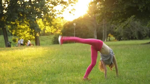 Küçük Kız Bir Akrobatik Tekerlek yaparken Yeşil Çim Üzerinde Eğlenmek. Genç Sportif Çocuk Gerçekten İyi Bir Ruh Hali Var. — Stok video