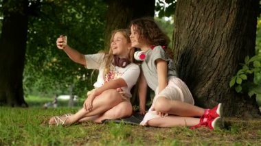 Çocukluk Zamanı. Selfie Çekerken Ve Cep Telefonu ile Müzik Dinlerken Parkta Eğlenen Sevimli Gülümseyen Küçük Kızlar.