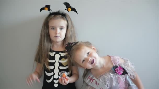 Due ragazze cutie in costumi di Halloween si stanno divertendo insieme. Costumi divertenti. Isolato . — Video Stock