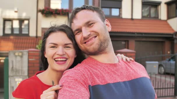 Lyckligt par välkomna i deras nya hus som visar dörren hus nycklar — Stockvideo