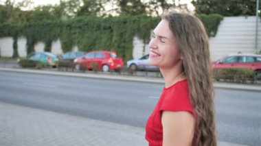 Modern şehir şehrinde sokakta yürüyen arka görüşte kadın. Kahverengi saçlı kadın sabahları yürür. yavaş çekim