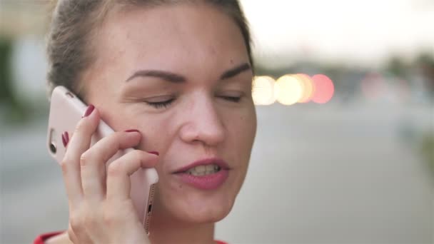 Hermosa mujer hablando teléfono en el fondo de la calle de la ciudad. Retrato de chica feliz hablando en el teléfono inteligente en chaise longue . — Vídeos de Stock