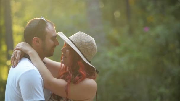 Romantiska par i parken kramar varandra under sommaren. De tittar på varandra. Lyckliga tillsammans. — Stockvideo