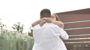 Aşık genç çift eski binanın önünde şehir merkezinde eğleniyor. Esmer adam tutan ve güzel kadın iplik.