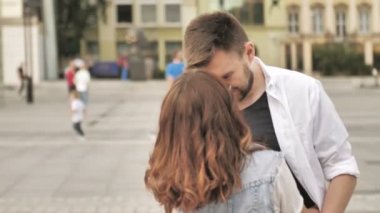 Sevgi dolu genç çift kucaklayan ve şehirde bir sokakta birlikte dururken romantik bir öpücük paylaşımı