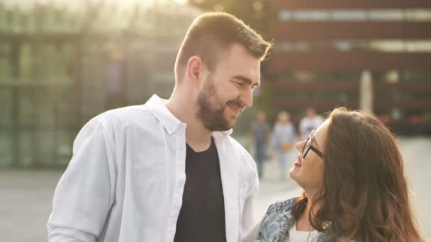 Mosolygó szerelmesek a szabadban. Fiatal boldog pár ölelkezik a város utcáin. — Stock videók