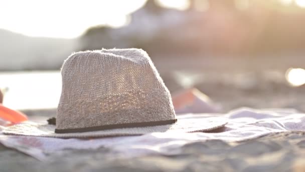 Strohhut floppt an einem tropischen Strand. Mädchen nimmt eine Kopfbedeckung. — Stockvideo