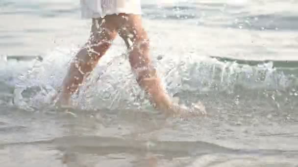 Jambes de femme sur une plage de sable fin. Fille marchant sur le sable près de la mer. Voyage à la plage. Concepts des vacances d'été . — Video