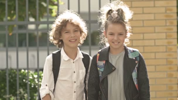 Portrety dzieci z plecakami w pobliżu szkoły - koncepcja nauki — Wideo stockowe