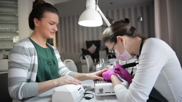 Zbliżenie Hardware manicure w salonie piękności. Manicurist Użyj Electric paznokci plik wiertarka do manicure na kobiece palce. — Wideo stockowe